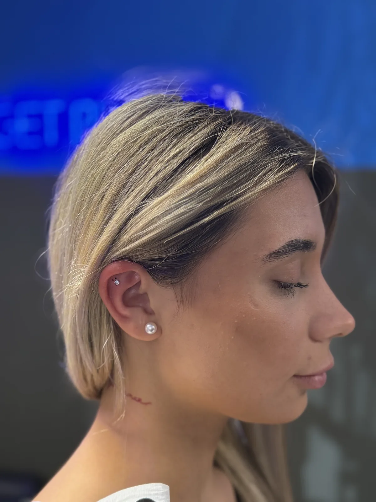 Piercing Nürnberg – Kundin im Profil mit Ohrpiercing