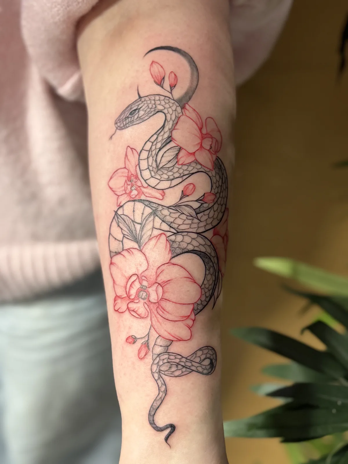 Fineline-Tattoo: Schlange mit roten Blüten am Oberarm – Trustinkus Nürnberg