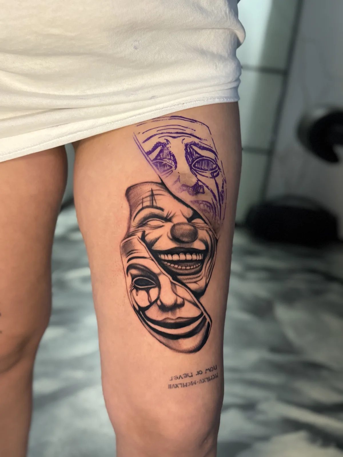 Newschool-Tattoo mit Theatermasken in Schwarz und Violett am Oberschenkel – Trustinkus Nürnberg